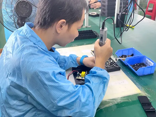 Factory worker assembling industrial routers during the production process